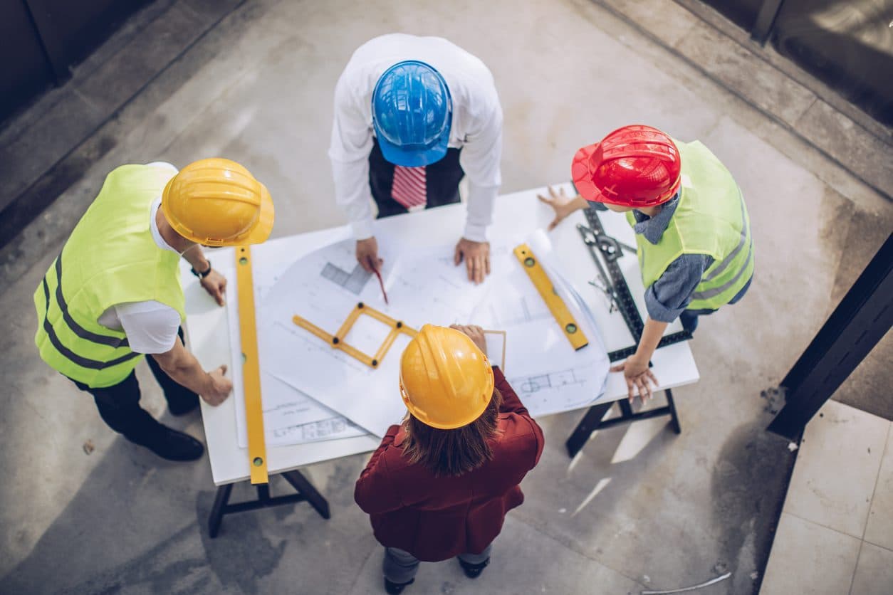Construction workers and architects working on construction site