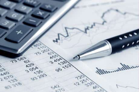 Reviewing school financial reports and budget data with a calculator and pen