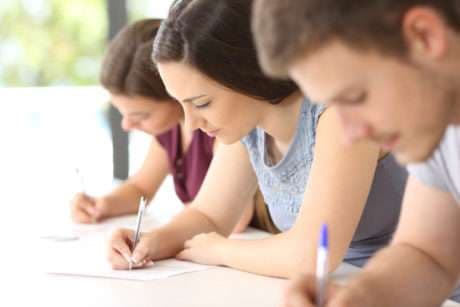 Students focused on writing during an exam or class.